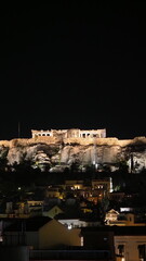 Cityscape of Athens with illuminated Acropolis hill, Pathenon and sea at night, Greece