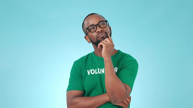 Thinking, volunteer and a black man on a blue background for planning, vision or charity work. Help, community and an African person or volunteering worker with a humanitarian idea or decision