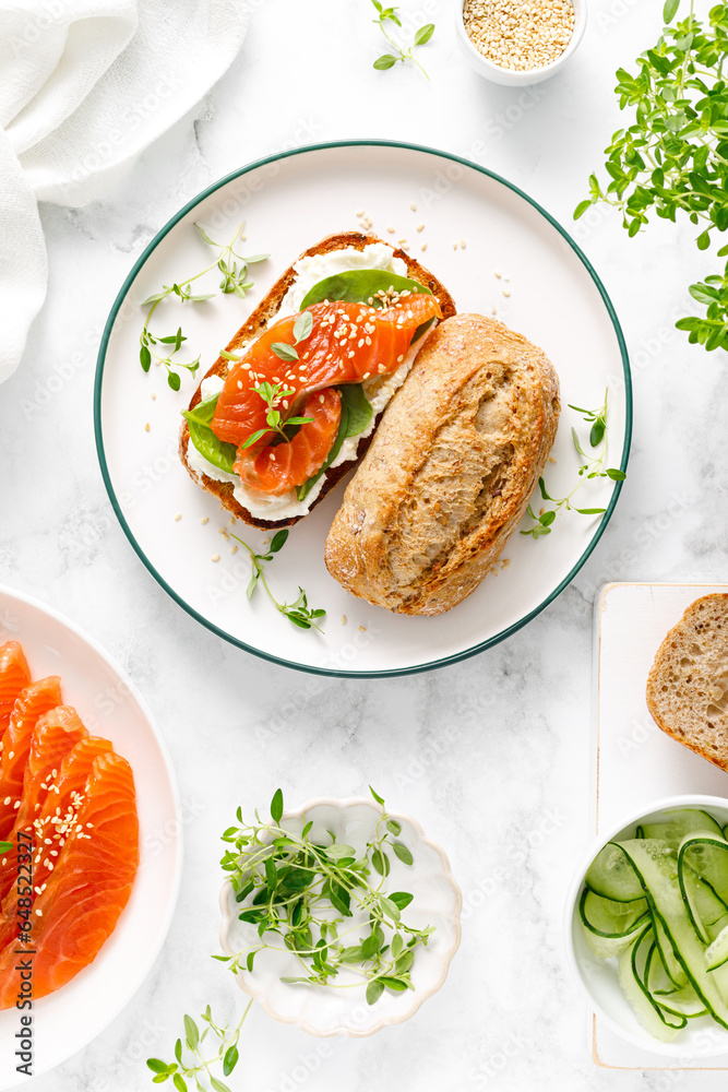 Wall mural salmon salted sandwich with spinach and cream cheese, top down view