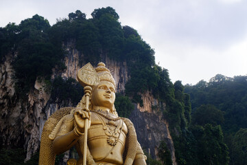 Fototapeta na wymiar Batu caves in Malaysia, gold indian statue of Lord Murugan