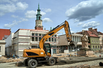 Excavator during renovation of the Old Market Square with the historic town hall in Poznan - obrazy, fototapety, plakaty