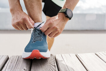 A smart watch for fitness, an athlete uses a mobile app and running shoes.