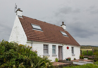 Small scottish croft with a bridge at the front door - obrazy, fototapety, plakaty