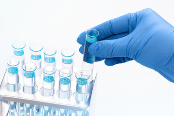 Scientist taking test tube with light blue liquid, closeup. Laboratory, equipment.