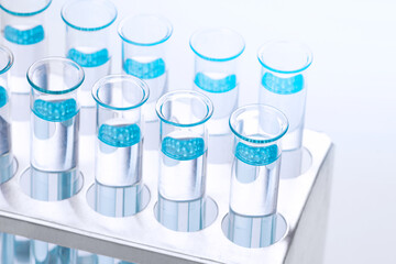 Scientific laboratory test tubes with light blue liquid, closeup. Laboratory, equipment