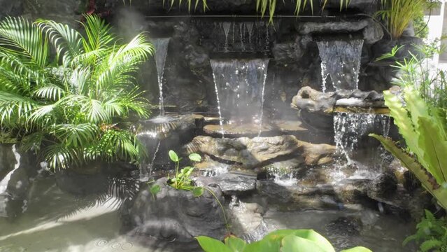 Green Nature Garden decoration of Mini waterfall set with stone and tropical fern plant forest patterns in the garden