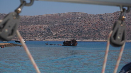 A group of unrecognizable divers explore a sunken shipwreck in the blue, mediterranean sea at Naxos...