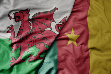 big waving national colorful flag of wales and national flag of cameroon .