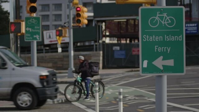 slow motion Ebike passes Staten Island Ferry bike lane sign