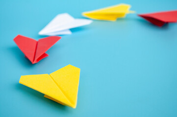 Yellow paper plane origami leading other paper planes on blue background. Leadership and copy space.