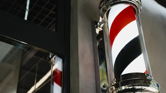 Close-up of a rotating barber shop pole. The barbershop logo rotates when entering the haircut studio.