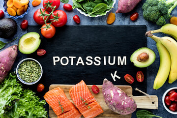 The word Potassium on a black slate board surrounded by foods high in potassium.