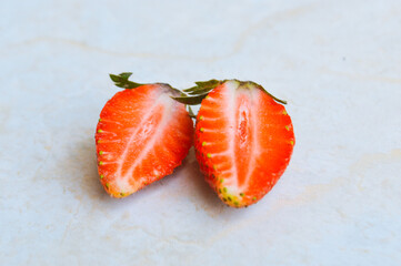 Close-up View Of Freshly Sliced Organic Strawberries, Halved Lengthwise, Isolated On White Floor Background