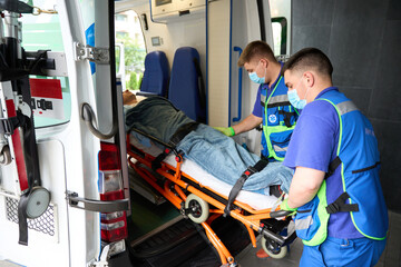 Young paramedics unload a patient from an ambulance © Svitlana