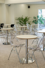 Seating inside the cafe or restaurant, with transparent chairs and white tables.