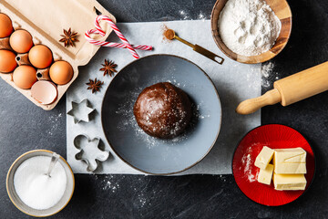 baking, cooking and food concept - close up of gingerbread dough and ingredients on black table top