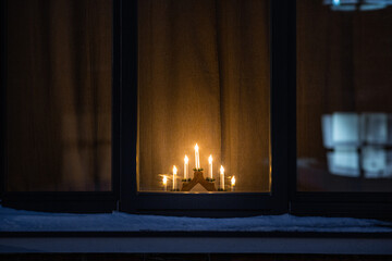 winter holidays and celebration concept - advent candlestick on window sill at night