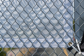 Fototapeta premium chain link fence and fabric banner (verso side) with plastic ties on a footbridge 