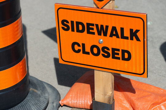 construction sign warning pedestrians and others that a sidewalk is no longer clear to walk along