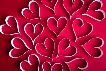 White paper hearts on the red paper background. Valentine background concept. - 648591959