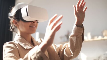 Beautiful young female playing game in vr glasses. Happy woman touch something using modern virtual reality glasses. Augmented Reality. Student playing using VR glasses on a sunny day. Slow motion  - Powered by Adobe