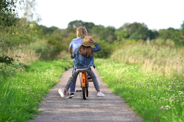 zwei Kinder fahren mit dem Rad durch die Natur