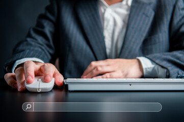 Businessman using a laptop with a search bar background.