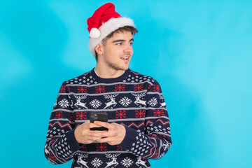 young man with santa claus hat and mobile phone