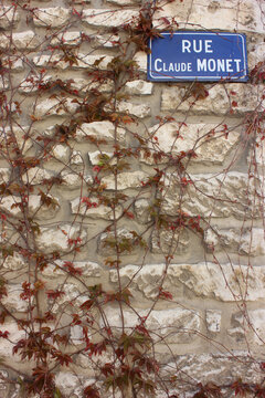 Street signal named after the famous French painter and founder of impressionism, seen as a key precursor to modernism on wall covered with ivy. Giverny France. 
