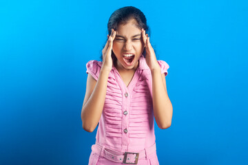 Stressed asian little girl holding her head and suffering from headache