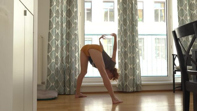 Young woman doing stretching at home