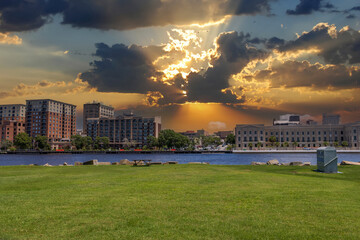 A beautiful summer landscape along Cape Fear river with lush green trees and grass, hotels and...