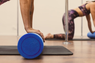 Close view of detail two fitness women performing hypopressive arm exercise at pole dance academy