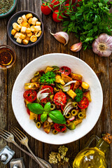 Italian style food - panzanella salad on wooden table
