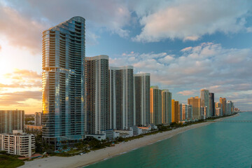Fototapeta na wymiar Aerial view of Sunny Isles Beach city with luxurious highrise hotels and condos on Atlantic ocean shore at sunset. American tourism infrastructure in southern Florida