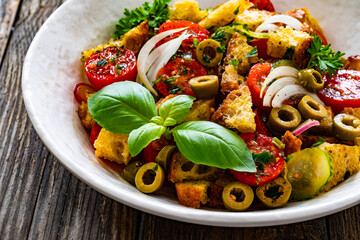 Italian style food - panzanella salad on wooden table
