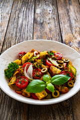 Italian style food - panzanella salad on wooden table
