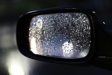 Raindrops on the rearview mirror of the car