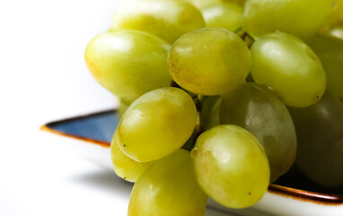 small bunch of natural ripe grapes on a white background. close-up