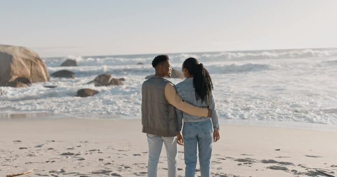 Black couple, walking and beach with back, love and care together by the sea by water. Happy, freedom and vacation with young people relax with embrace by the ocean on adventure with travel