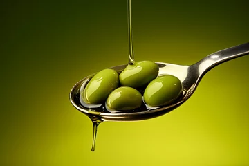 Fototapeten Green olives and olive oil in a spoon on a green background, beautiful food composition © Zelma