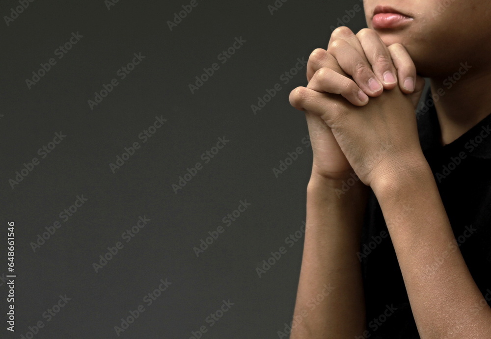 Wall mural boy praying to God with hands held together with closed eyes with people stock image stock photo