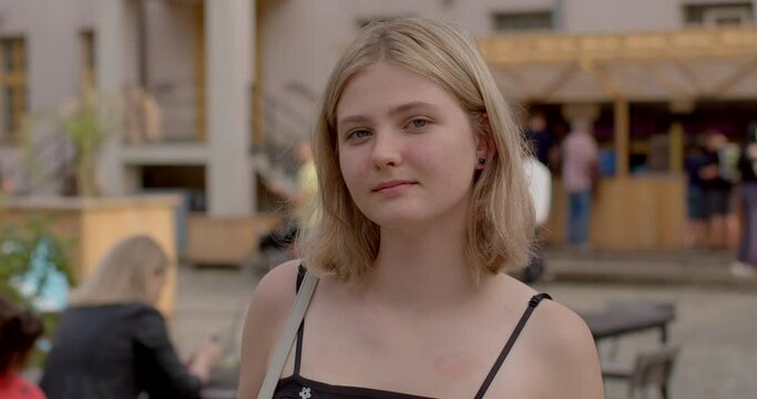 Youth portrait of teenage girl student in urban surroundings gazing into the camera. Student in urban environment. Youthful energy and curiosity, young woman on the cusp of adulthood. People lifestyle