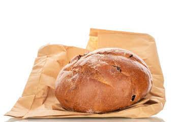 A loaf of bread with raisins on a paper bag, macro, isolated on a white background.