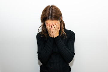 40 year old woman with her hands covering her face due to anxiety and helplessness. mental health
