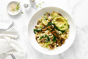 Couscous with avocado, spinach and sauteed champignon mushrooms with onion, top down view - 648667131