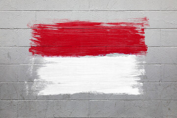 Monaco flag colors painted on brick wall