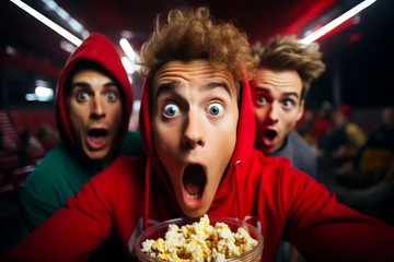 Foto op Canvas Bright facial expression, human emotions concept. Funny portrait of two young teenagers scared shocked or impressed group with popcorn in hands.  Enjoy watching horror movie or thriller in the cinema © Valeriia