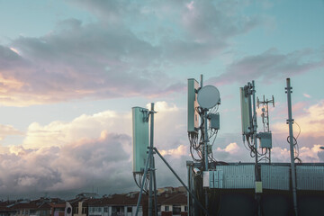 GSM mobile transmitter antennas on the building roof. - obrazy, fototapety, plakaty