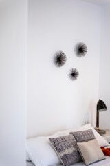 Modern bedroom interior decoration still on a white wall with some pillows and black spider decoration